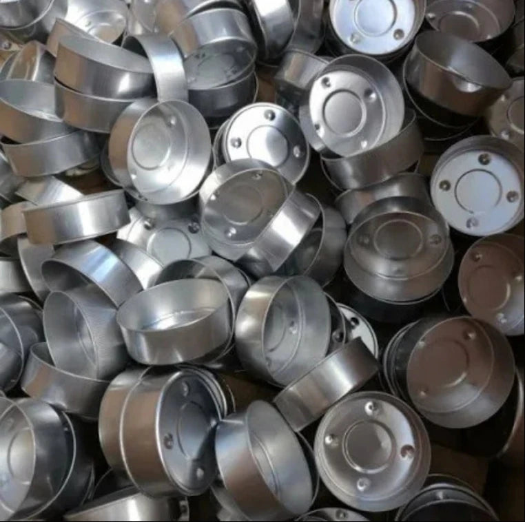 Top view of multiple aluminum tealight cups arranged for candle making supplies