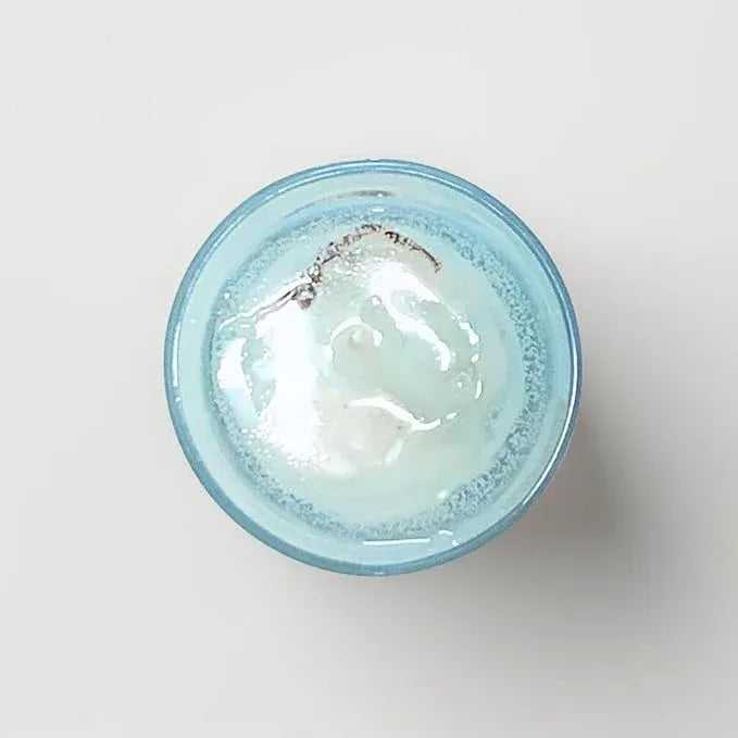 Top view of beach theme candle with blue wax and shell decoration