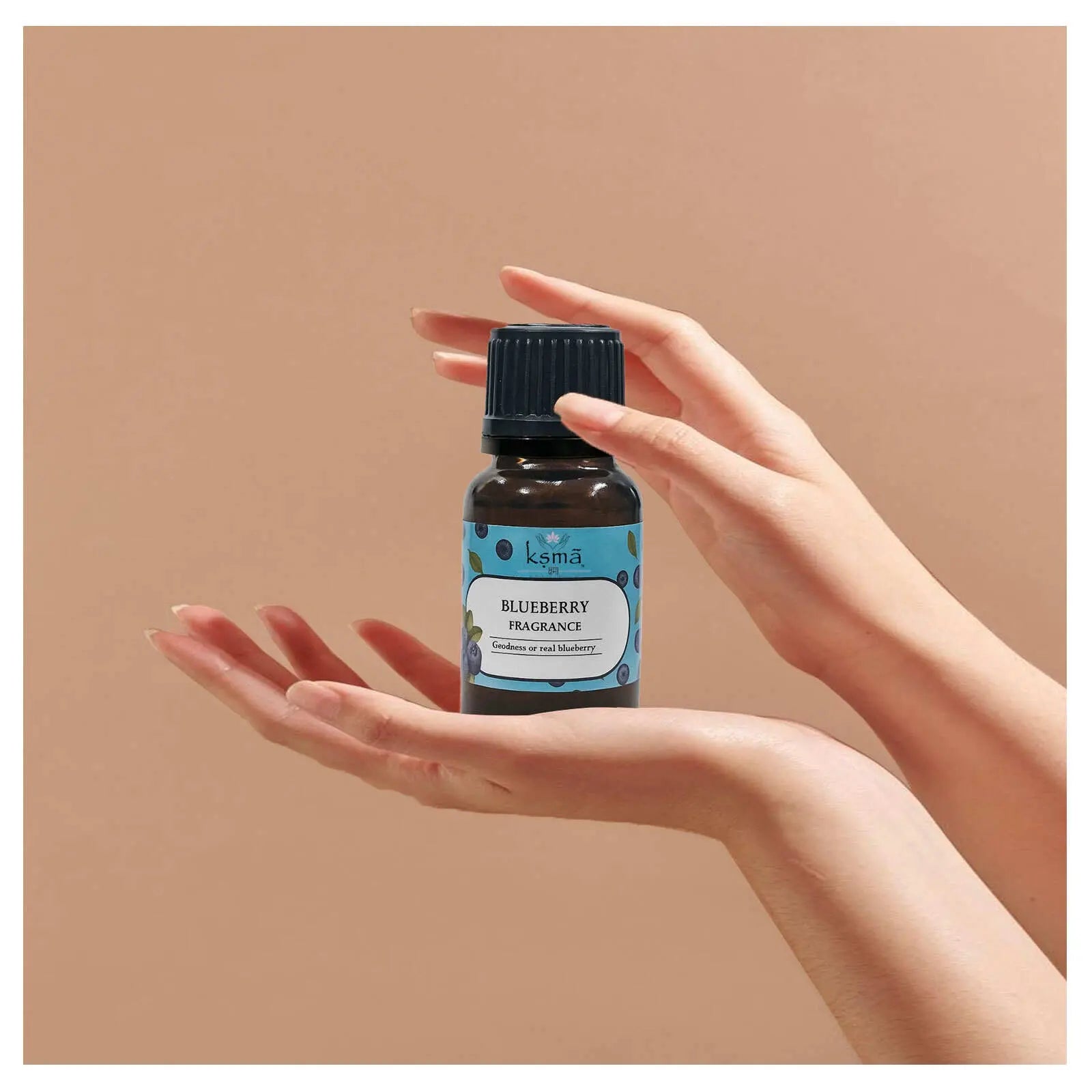 Blueberry fragrance oil arranged in flatlay with fresh blueberries and decorative elements