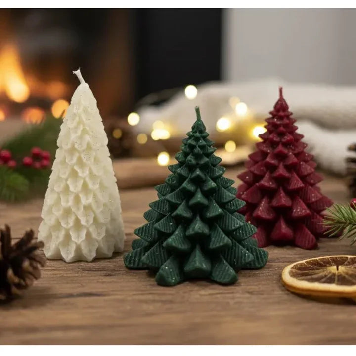 Set of three Christmas tree candles in white green and red placed together on wooden surface