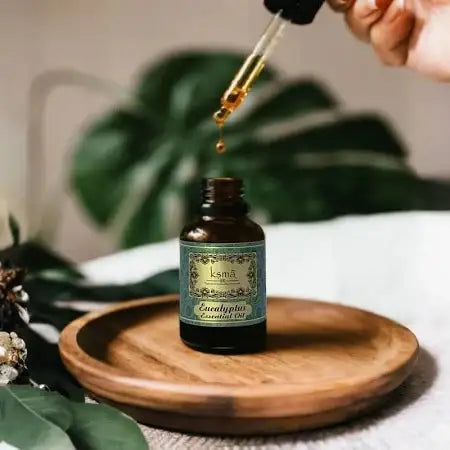 Eucalyptus essential oil bottle with dropper placed on wooden surface