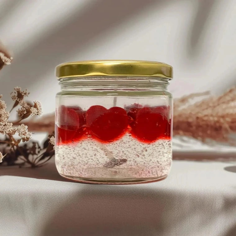 Glass jar candle with layered wax and heart decorations