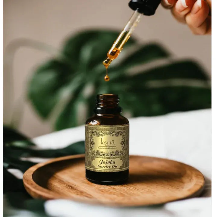 Jojoba carrier oil bottle with dropper placed on wooden surface