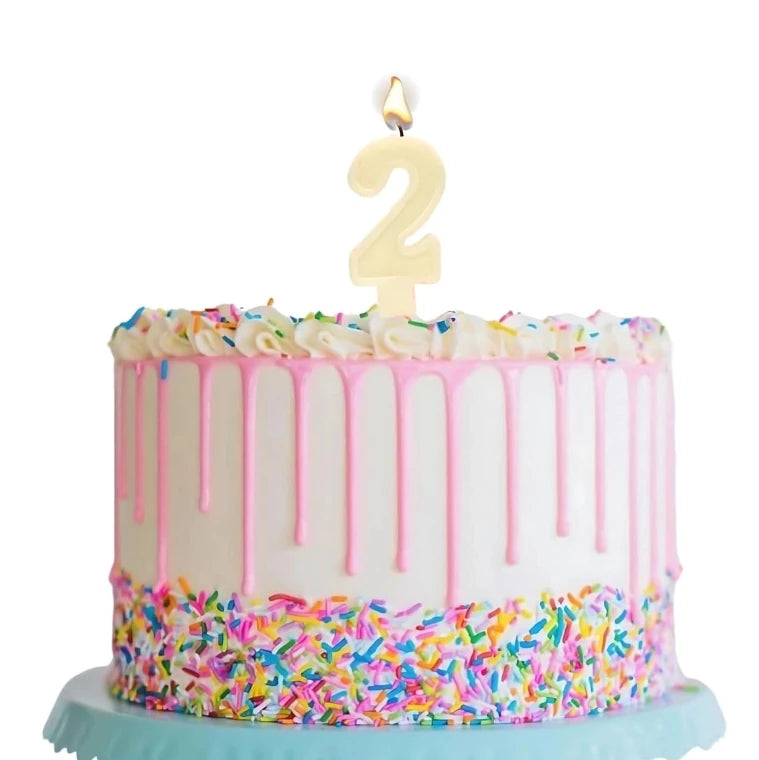 Number 2 birthday candle placed on decorated cake