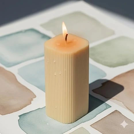 Decorative pillar candle placed with small plant in home decor setting